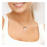 Une femme vêtue d'un haut blanc sans manches sourit doucement, portant le Perlinea Collier FLOWERS | Perle de Culture Blanche avec un pendentif circulaire orné d'une perle d'eau douce et de pierres précieuses colorées.