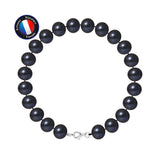 Un bracelet Perlinea NOELYSE noir avec des perles de 9/10 mm et un fermoir homard en argent 925 est disposé en cercle sur fond blanc. Un écusson rond en haut à gauche montre le drapeau français et le texte "Maison Bijouterie Française".