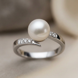 Anillo de oro blanco adornado con diamantes y perla blanca.