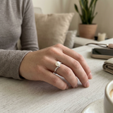 Anillo de oro blanco adornado con diamantes y perla blanca.