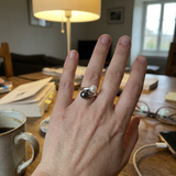 Bague toi et moi en argent 925 avec perle de Tahiti noire et perle de culture blanche, portée à la main.