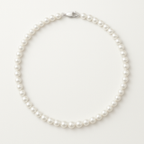 Le Collier NOELYSE de Perlinea est composé de perles d'eau douce blanches de 5/6 mm et d'un fermoir mousqueton en argent, élégamment disposés en un seul brin sur un fond blanc uni.