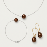 Parure trois pièces perles chocolat : collier et bracelet chaîne argentée, boucles dorées.