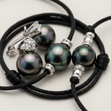 Parure collier, bracelet et boucles d'oreilles avec perles de Tahiti et détails argentés.