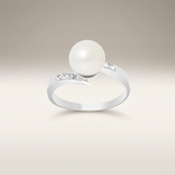 Anillo de oro blanco adornado con diamantes y perla blanca.