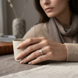 Anillo de oro blanco adornado con diamantes y perla blanca.