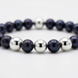Bracelet perles d'eau douce noires et billes argent 925 sur fond blanc.