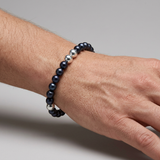Bracelet perles d'eau douce noires et argent 925 porté au poignet d'un homme.