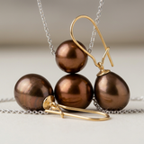 Parure collier et boucles d'oreilles à perles chocolat sur chaîne argentée avec crochets dorés.